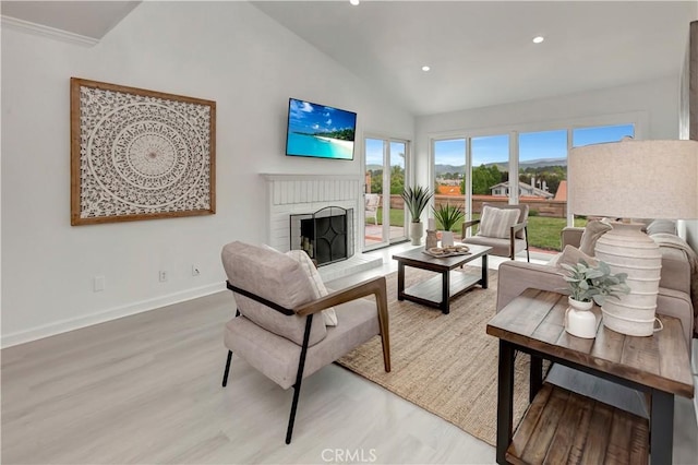living room with a brick fireplace, baseboards, recessed lighting, light wood-style flooring, and vaulted ceiling