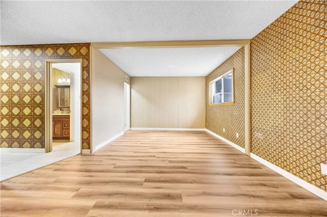 20908 New Hampshire Ave, Torrance, CA 90502 - bonus room with wallpapered walls, a textured ceiling, baseboards, wood finished floors, and an accent wall
