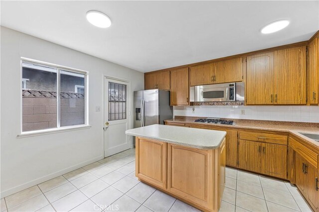 20908 New Hampshire Ave, Torrance, CA 90502 - kitchen with appliances with stainless steel finishes, a kitchen island, light tile patterned floors, and backsplash