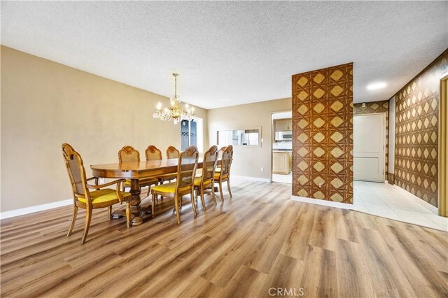 20908 New Hampshire Ave, Torrance, CA 90502 - dining area featuring a chandelier, light wood finished floors, a textured ceiling, and baseboards