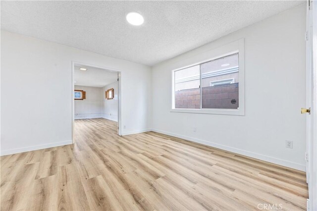 20908 New Hampshire Ave, Torrance, CA 90502 - unfurnished room with light wood-style floors, a textured ceiling, and baseboards