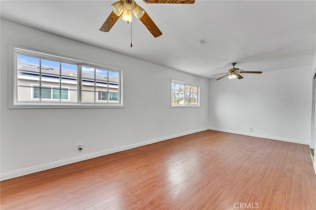 empty room with a ceiling fan, baseboards, and wood finished floors