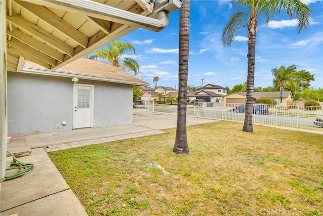 view of yard featuring a residential view, fence, and a patio