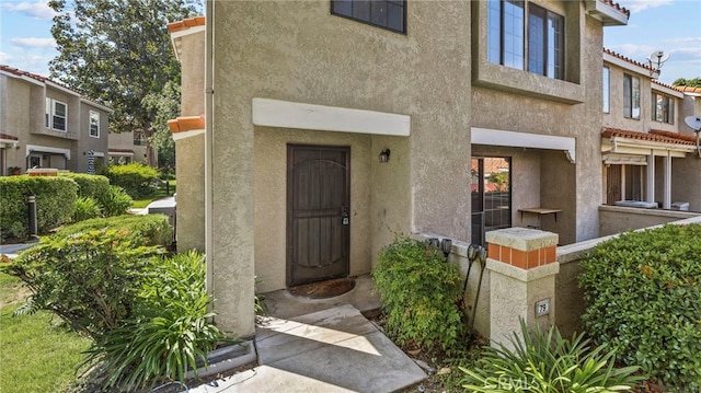 entrance to property featuring stucco siding