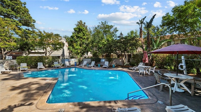 community pool featuring a patio and fence
