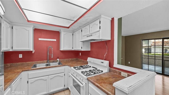 kitchen featuring a sink, white cabinetry, under cabinet range hood, and white appliances