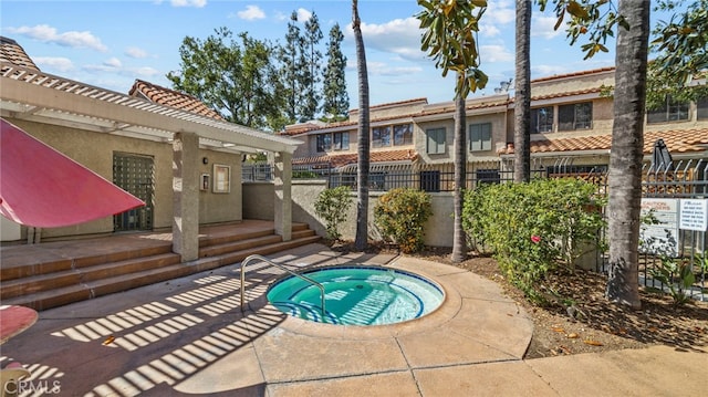 view of pool with a community hot tub and fence