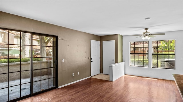 interior space featuring baseboards, a ceiling fan, and wood finished floors