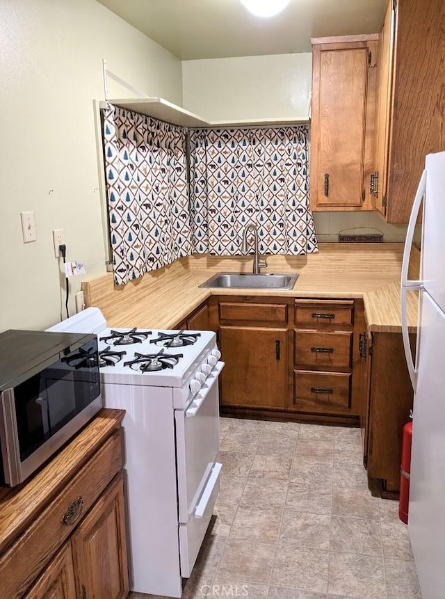 23800 Scenic Dr, Crestline, CA 92325 - kitchen with brown cabinetry, white appliances, light countertops, and a sink
