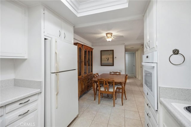 124 Via Estrada Unit D, Laguna Woods, CA 92637 - kitchen featuring white cabinets, light tile patterned floors, white appliances, and light countertops