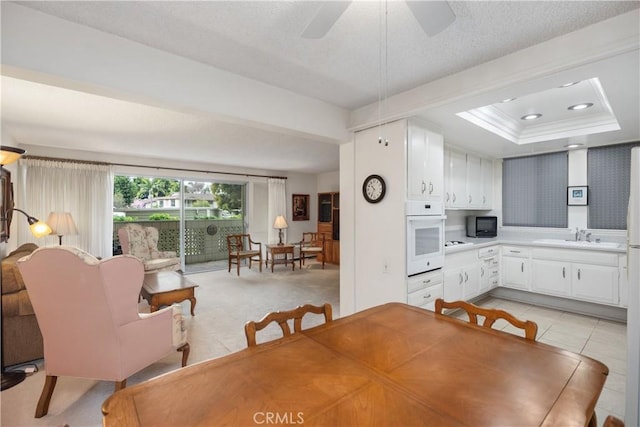 124 Via Estrada Unit D, Laguna Woods, CA 92637 - dining room with a ceiling fan, a textured ceiling, and a tray ceiling