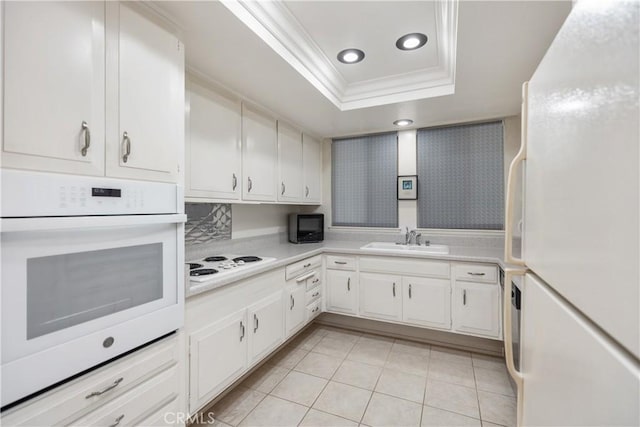 124 Via Estrada Unit D, Laguna Woods, CA 92637 - kitchen with crown molding, a sink, a raised ceiling, light countertops, and white appliances
