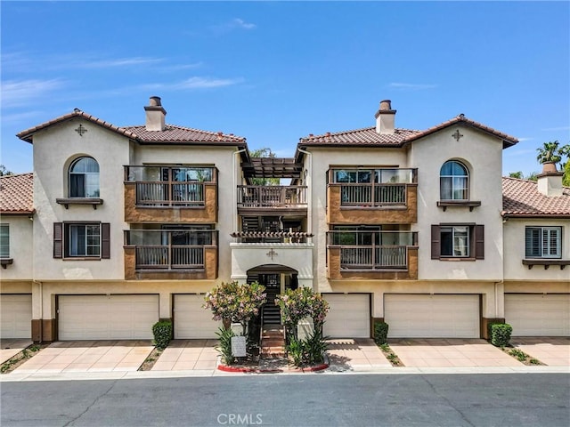 2960 Champion Way Unit 2706, Tustin, CA 92782 - view of front of home featuring a garage, stucco siding, and a chimney