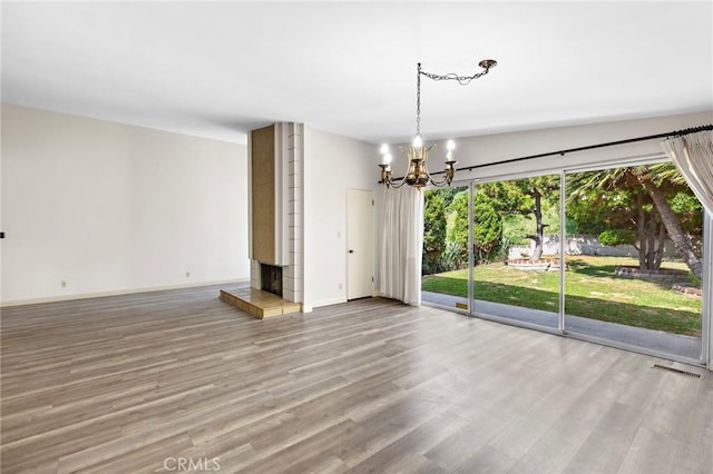 851 Crest Vista Dr, Monterey Park, CA 91754 - spare room with wood finished floors, a chandelier, a tile fireplace, and baseboards