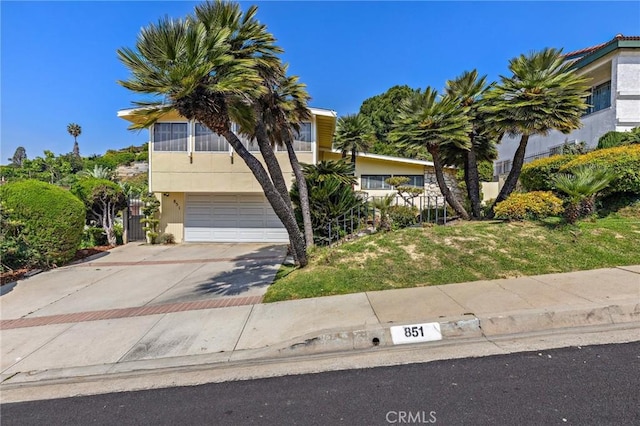 851 Crest Vista Dr, Monterey Park, CA 91754 - view of property hidden behind natural elements featuring stucco siding, a front yard, concrete driveway, and an attached garage