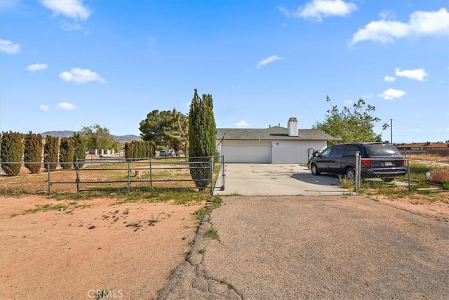 ranch-style home with driveway, fence, and an attached garage