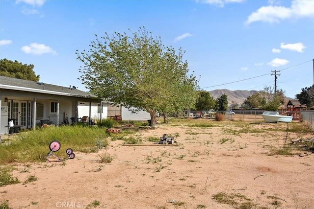 view of yard featuring fence and a mountain view