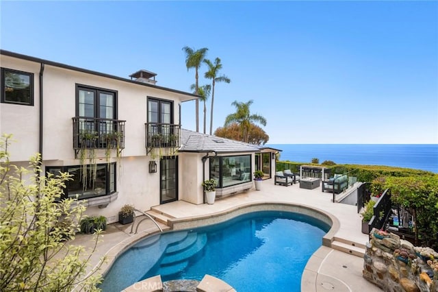 pool featuring a patio, an outdoor living space, a water view, and french doors