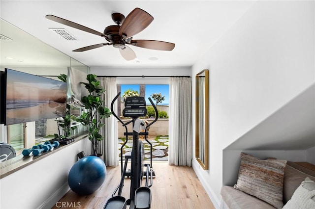 workout room featuring light wood finished floors, visible vents, ceiling fan, and baseboards