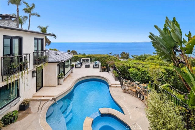 view of pool featuring a patio, a pool with connected hot tub, and a water view