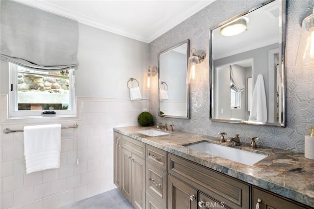bathroom featuring tile patterned floors, double vanity, ornamental molding, and a sink