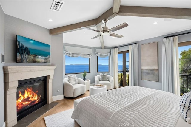 bedroom with recessed lighting, visible vents, beam ceiling, and a glass covered fireplace