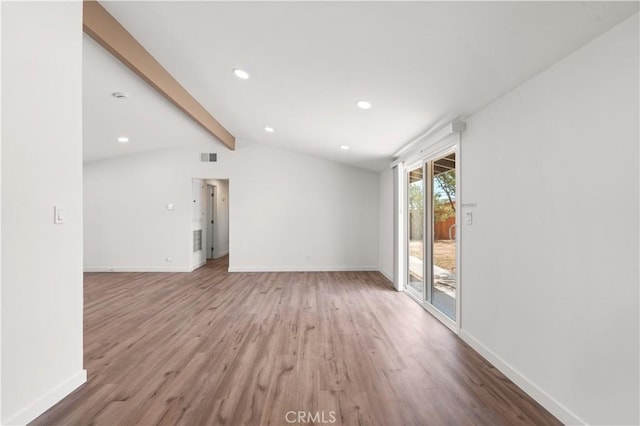 interior space featuring wood finished floors, lofted ceiling with beams, visible vents, and baseboards