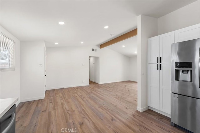 kitchen with white cabinets, lofted ceiling with beams, light wood-style floors, and appliances with stainless steel finishes