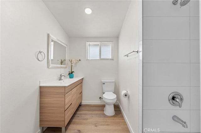 full bath featuring vanity, toilet, baseboards, walk in shower, and wood finished floors