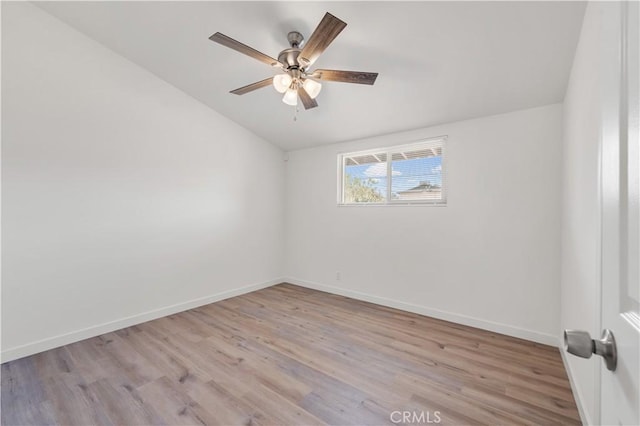 empty room with lofted ceiling, light wood-style floors, ceiling fan, and baseboards
