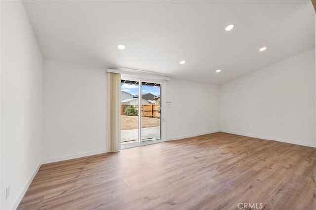 empty room with light wood-style floors, recessed lighting, and baseboards