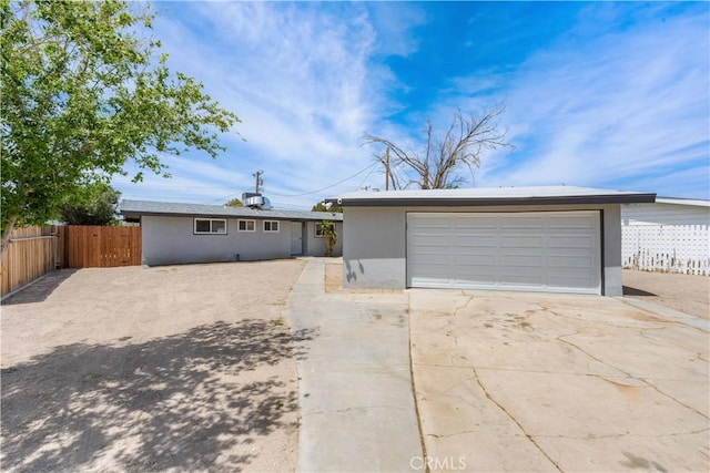 ranch-style home featuring fence, a detached garage, stucco siding, and an outbuilding