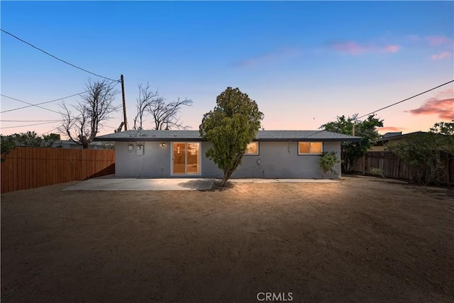 rear view of house with a fenced backyard and a patio area