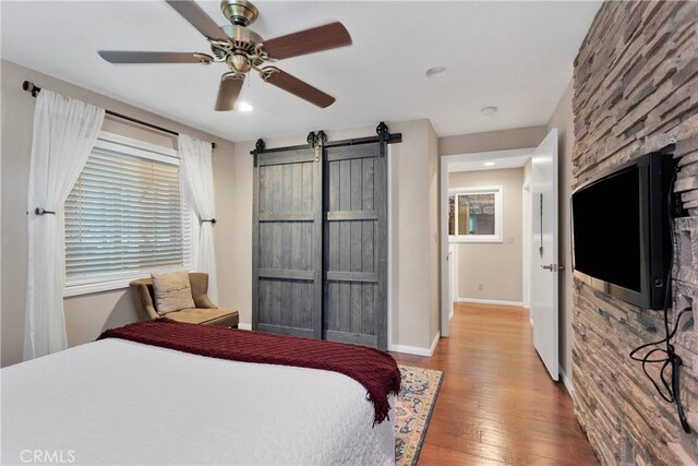 825 Grass Valley Rd, Lake Arrowhead, CA 92352 - bedroom with baseboards, a barn door, wood finished floors, and multiple windows