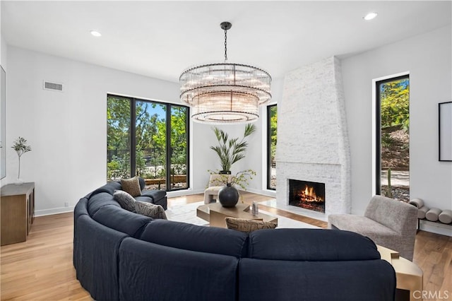 1935 Maverick Ln, North Tustin, CA 92705 - living room with recessed lighting, an inviting chandelier, a fireplace, light wood-style floors, and visible vents