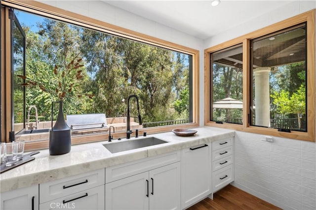 1935 Maverick Ln, North Tustin, CA 92705 - kitchen with white cabinetry, light stone countertops, a healthy amount of sunlight, and a sink
