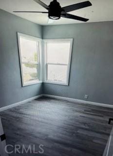spare room with a ceiling fan, wood finished floors, and baseboards