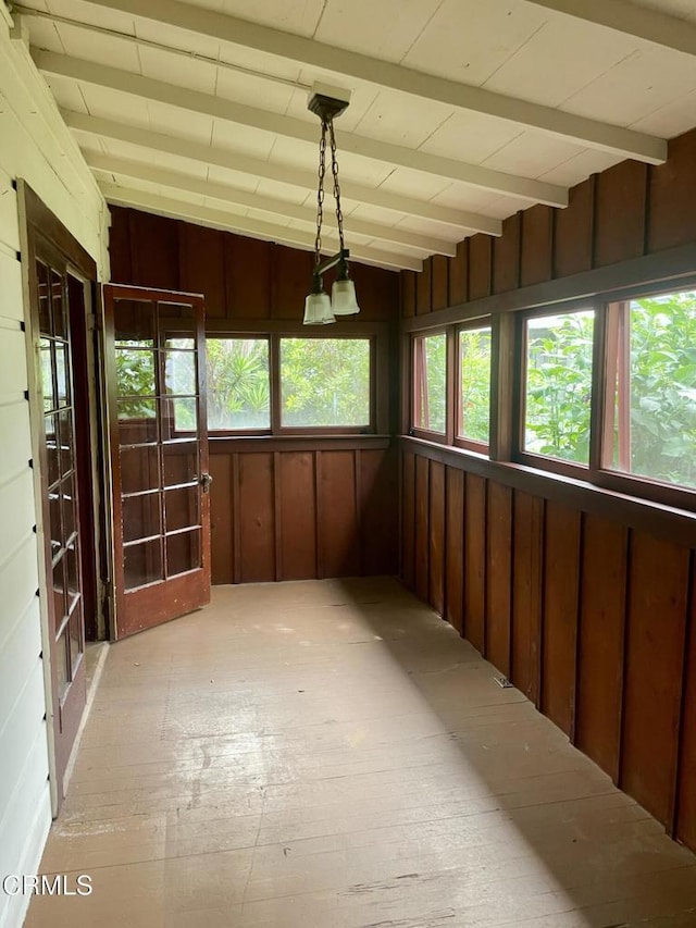 unfurnished sunroom with wood walls and vaulted ceiling