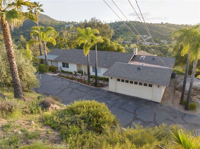 12140 Lilac Knolls Rd, Valley Center, CA 92082 - exterior space featuring a chimney, a shingled roof, a mountain view, stucco siding, and a garage