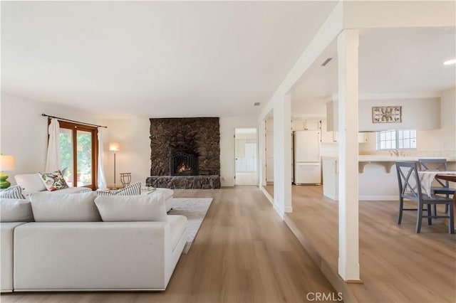 12140 Lilac Knolls Rd, Valley Center, CA 92082 - living room featuring a stone fireplace and light wood-style flooring