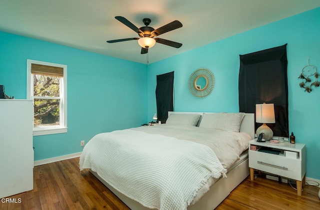 bedroom featuring ceiling fan, wood finished floors, and baseboards