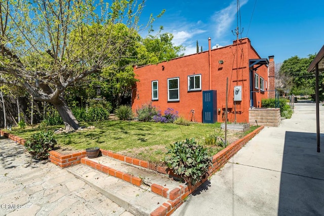 view of home's exterior featuring a lawn and stucco siding