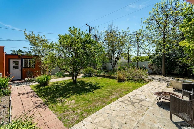 view of yard featuring a patio area, a fire pit, and fence