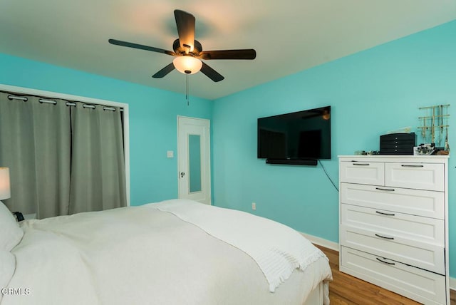 bedroom with wood finished floors, ceiling fan, and baseboards