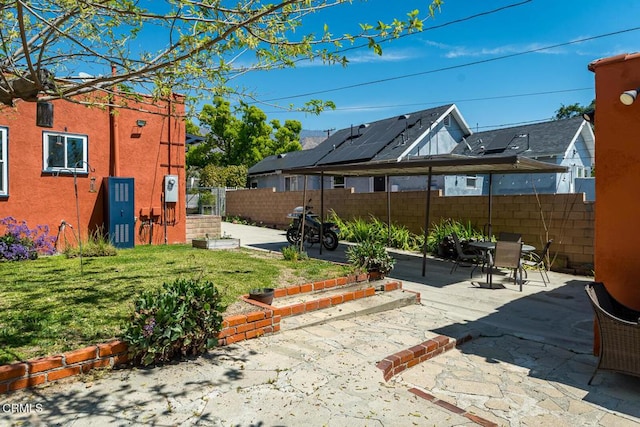 view of yard featuring a patio, outdoor dining space, and a fenced backyard