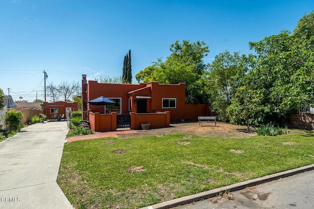 view of front of house with stucco siding, a fenced front yard, a gate, a front yard, and concrete driveway