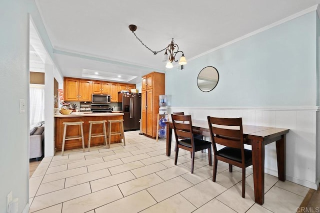 dining area featuring ornamental molding, light tile patterned flooring, and an inviting chandelier