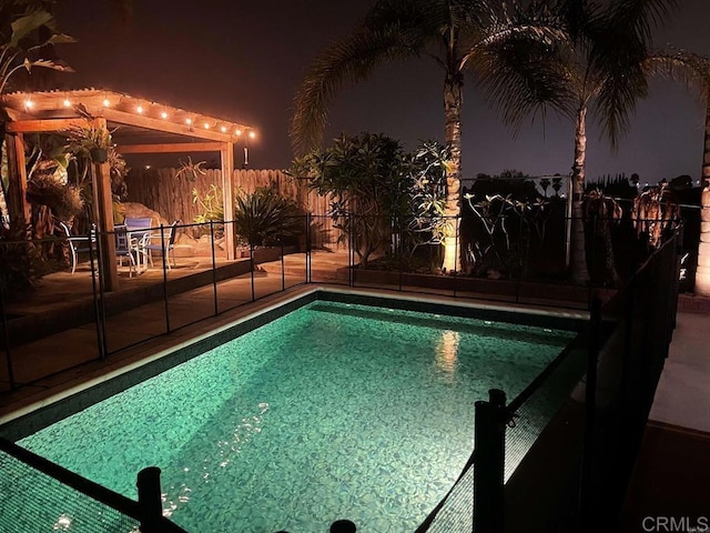 pool at twilight with fence, a patio, and a fenced in pool