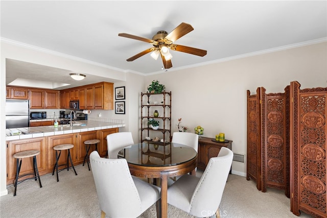 dining space with crown molding, a ceiling fan, and light carpet
