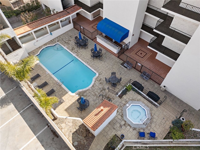 pool featuring a hot tub, outdoor dining space, and a patio area